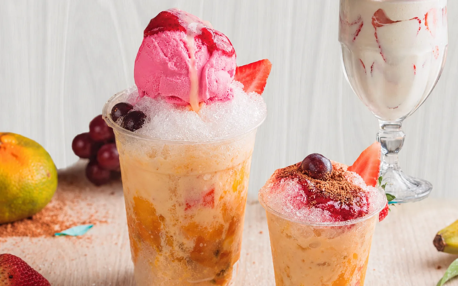 Dos vasos de cholao RanCholaos con helado de fresa, frutas frescas y crema, servidos en el local